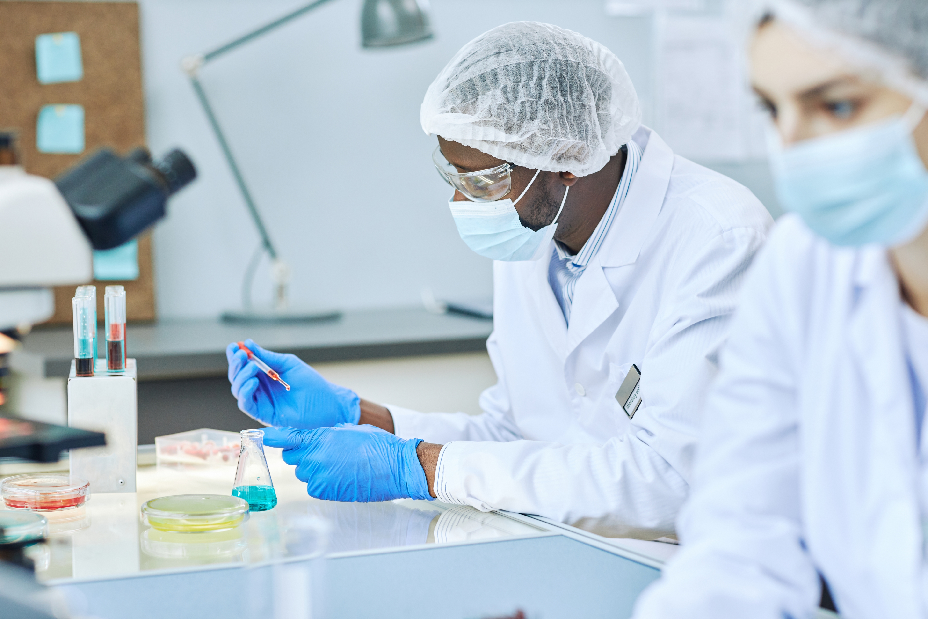 An image of an african man working in a labratory with lab gear on