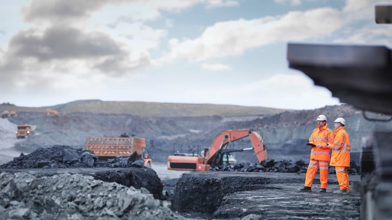 Engineers looking over mining operations while wearing PPE